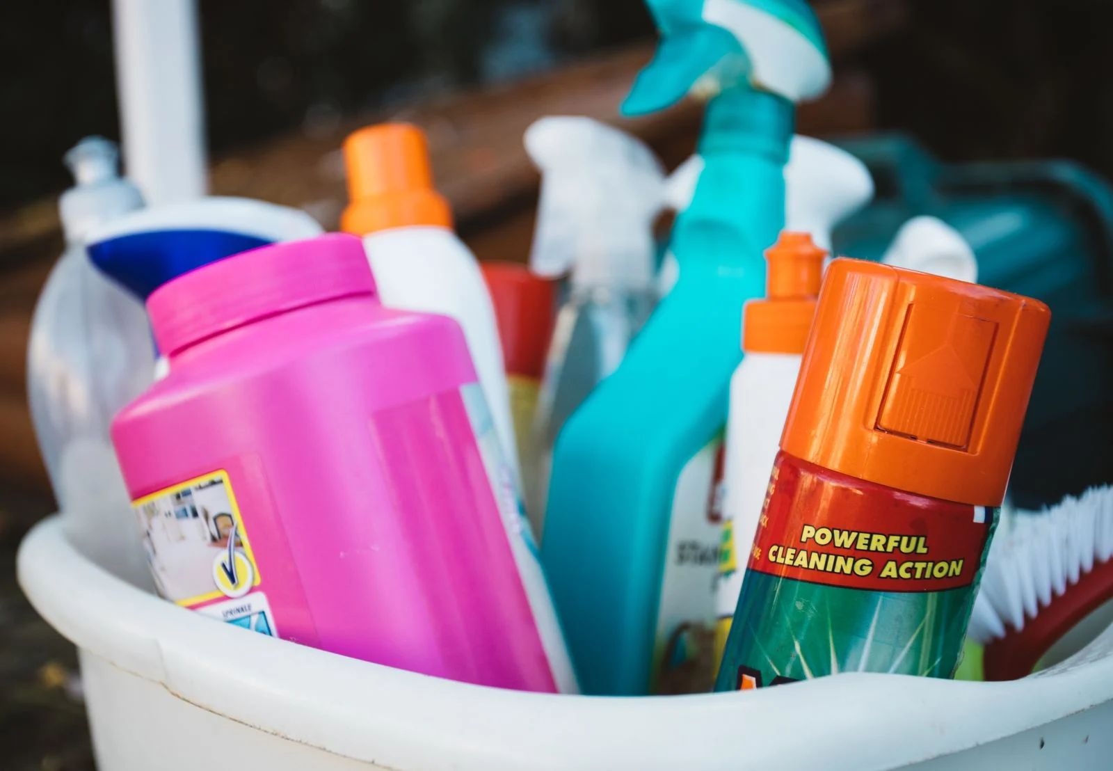 Cleaning bottles, sprays and brushes organized in a supply caddy